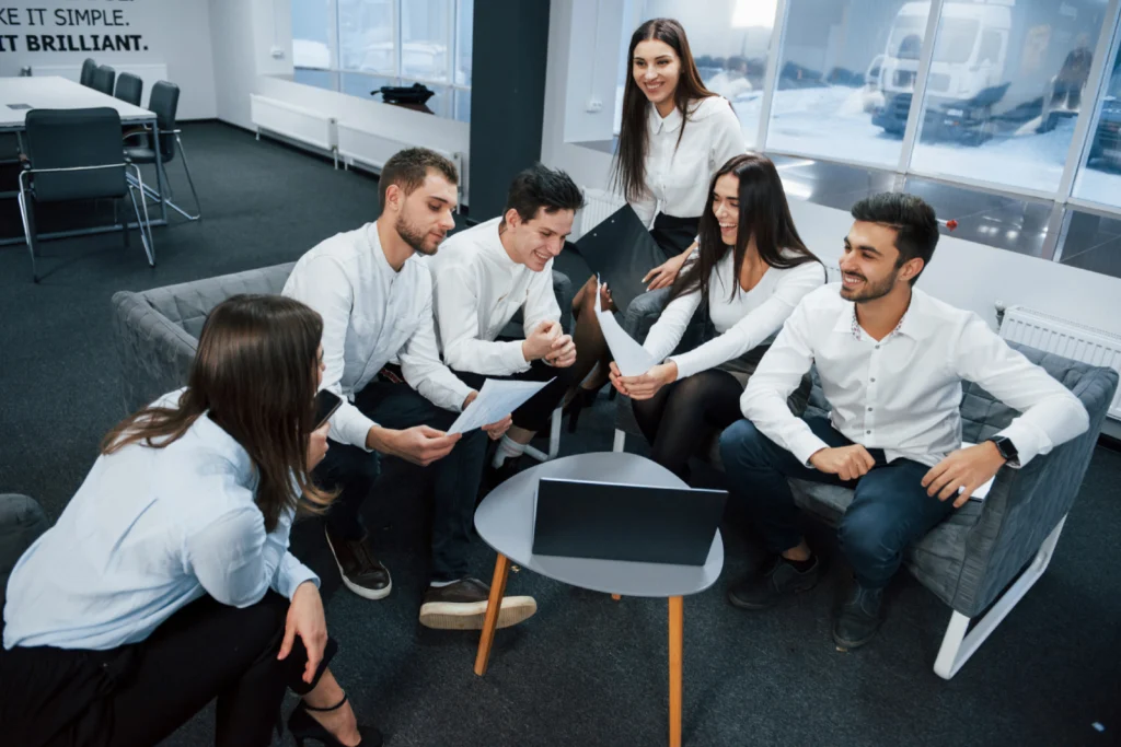 GettyImages-894602286 (1) A group of people sitting around a table.